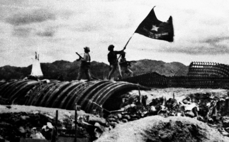 A Vietnamese soldier waves the national flag over the captured headquarters of the French army at Dien Bien Phu on May 7, 1954. More than 10&#039;000 French troops were captured after a 55 day siege,  ...