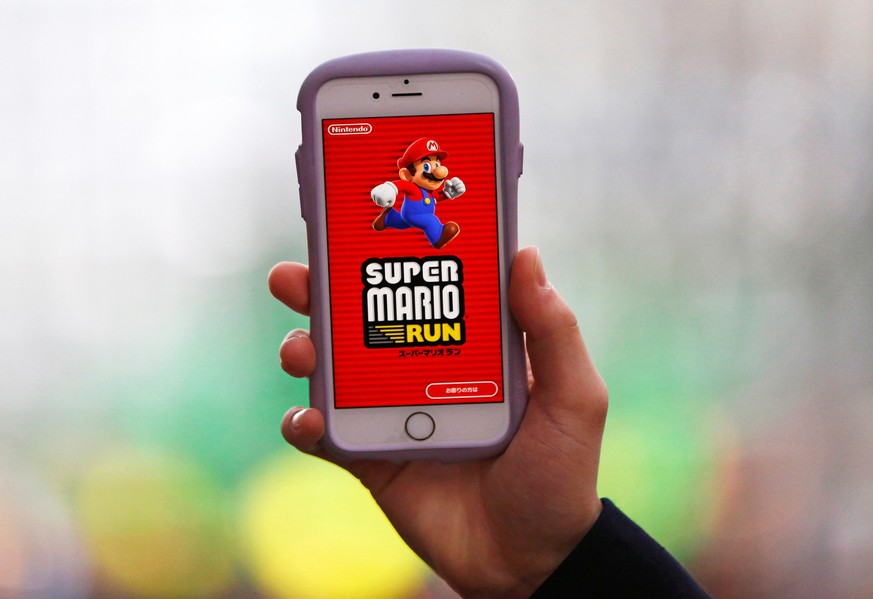 A person poses to display Nintendo&#039;s &quot;Super Mario Run&quot; game on a mobile phone in Tokyo, Japan, December 20, 2016. Picture taken on December 20, 2016. REUTERS/Kim Kyung-Hoon
