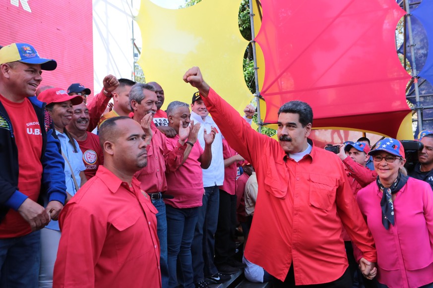 epa07541476 A handout photo made available by Miraflores&#039; Press Office shows Venezuelan President Nicolas Maduro (C) and his wife Cilia Flores (R) as they participate in an act on the ocassion of ...