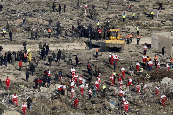 In this Wednesday, Jan. 8, 2020, photo, rescue workers search the scene where a Ukrainian plane crashed in Shahedshahr, southwest of the capital Tehran, Iran. Iran on Saturday, Jan. 11, acknowledged t ...