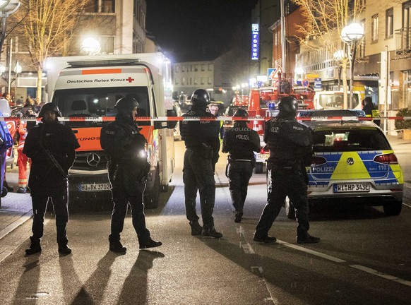 Police stand guard near the scene of a shooting in central Hanau, Germany Thursday, Feb. 20, 2020. German police say several people were shot to death in the city of Hanau on Wednesday evening. (AP Ph ...