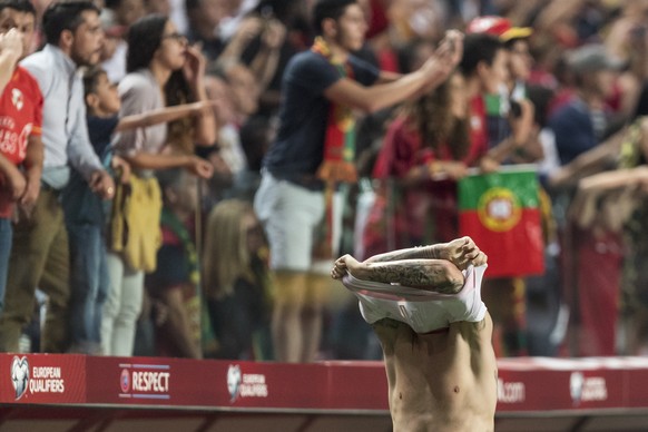 Switzerland&#039;s Steven Zuber takes off his shirt next to celebrating Portuguese fans, after the 2018 Fifa World Cup Russia group B qualification soccer match between Portugal and Switzerland at the ...