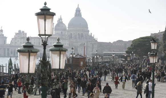 Tourists stroll in downtown Venice, Italy, Saturday, Nov. 12, 2016. Since 1951, Venice&#039;s population has steadily shrunk from 175,000 to some 55,000. Several factors are blamed, including high pri ...