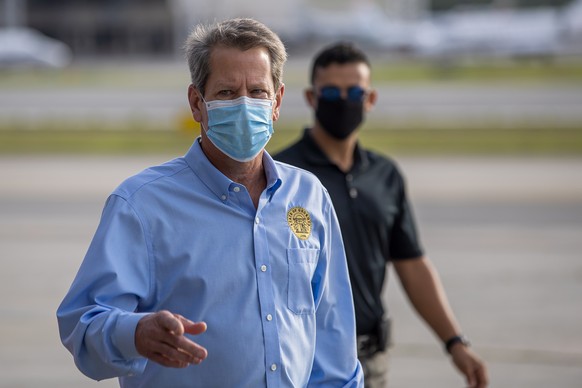 epa08521053 Georgia Governor Brian Kemp arrives for a press conference before embarking on a two-day &#039;Wear a Mask&#039; fly around tour of the state, at Peachtree Dekalb Airport in Atlanta, Georg ...