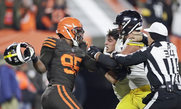 Cleveland Browns defensive end Myles Garrett, left, gets ready to hit Pittsburgh Steelers quarterback Mason Rudolph, second from left, with a helmet during the second half of an NFL football game Thur ...