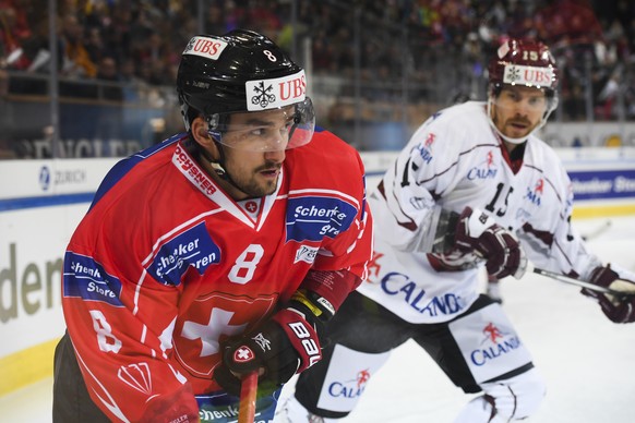 Team Suisse player Vincent Praplan, right, fights for the puck with Riga&#039;s Anssi Salmela, during the game between Team Suisse and Dinamo Riga at the 91th Spengler Cup ice hockey tournament in Dav ...