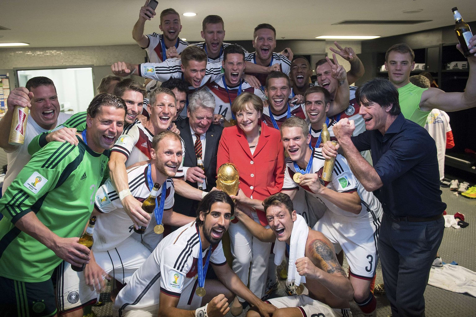 Gehört schon fast zur Familie: Kanzlerin Angela Merkel besucht die Weltmeister in der Kabine.