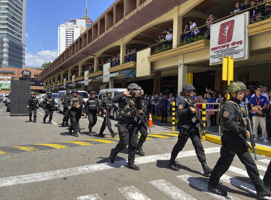 A group of armed police soldiers arrive at the Greenhills Shopping Center Monday, March 2, 2002, in San Juan city, Philippines. Philippine police on Monday surrounded a shopping mall in an upscale dis ...