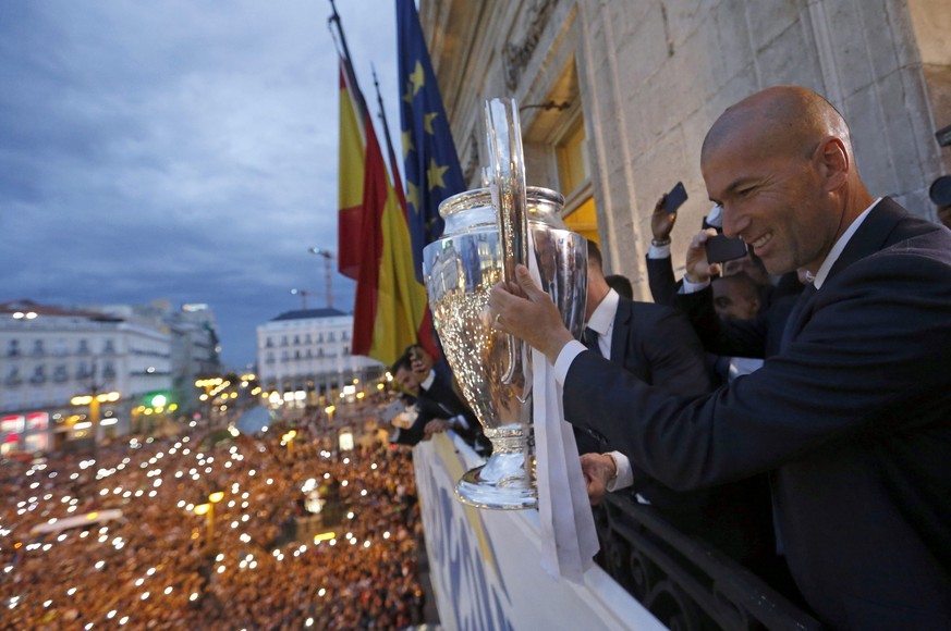 epa05336797 Real Madrid&#039;s head coach Zinedine Zidane holds the Champions League trophy as the head-coach, Zinedine Zidane, looks on, in the balcony of the Madrid Autonomous GovernmentŽs headquart ...