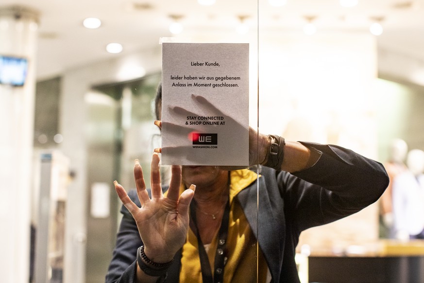 Eine Frau klebt eine Information an ein Schaufenster in einem Geschaeft an der Bahnhofstrasse in Zuerich am Montag, 16. Maerz 2020. Der Bundesrat hat den den nationalen Notstand erklärt. Ab Mitternach ...