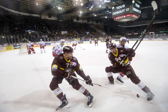 Geneve-Servette&#039;s center Tanner Richard, left, and Geneve-Servette&#039;s forward Tim Bozon #94, of France, vies for the puck with Lakers&#039; forward Jan Mosimann, right, during a National Leag ...