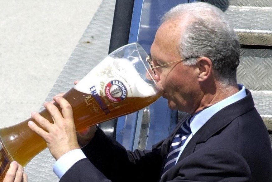 MUN81 - 20010524 - MUNICH, GERMANY : President of FC Bayern Munich Franz Beckenbauer, drinks a sip of beer from a giant glass Thursday 24 May 2001 after his arrival at Munich&#039;s airport. On Wednes ...