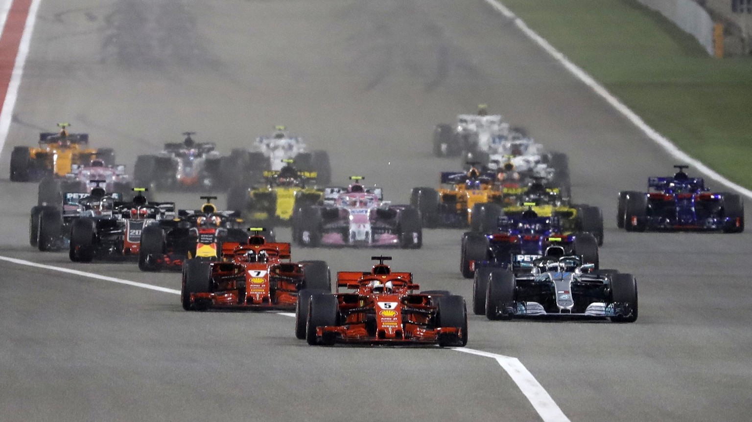 FILE- In this April 8, 2018 file photo, Ferrari driver Sebastian Vettel of Germany, center, leads at the start and followed by Mercedes driver Valtteri Bottas of Finland, right and Ferrari driver Kimi ...