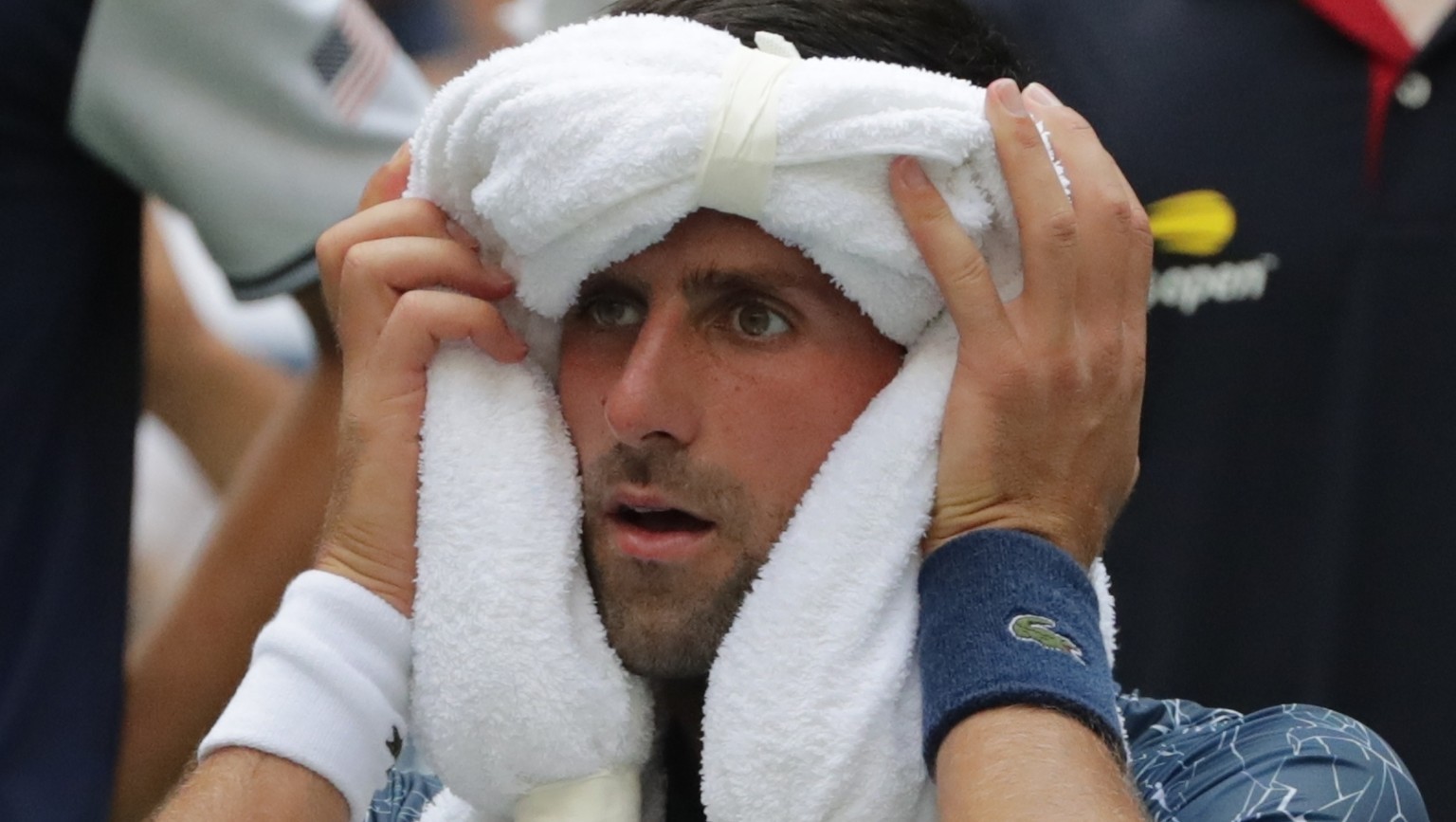 Novak Djokovic, of Serbia, uses ice towels to cool off during a changeover in his match against Marton Fucsovics, of Hungary, during the first round of the U.S. Open tennis tournament, Tuesday, Aug. 2 ...