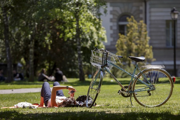 A cyclist enjoys the sunshine on the grass at The parc des Bastions, in Geneva, Switzerland, Wednesday, May 17, 2017. (KEYSTONE/Salvatore Di Nolfi)