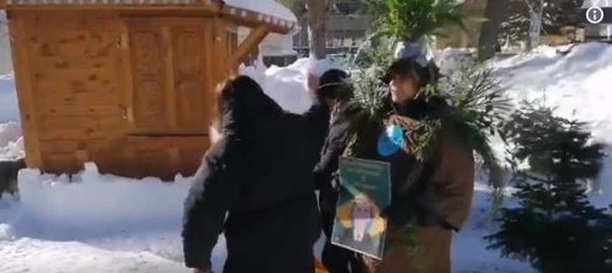 Eine Aktivistin richtet das Outfit ihrer Kollegen in Davos.