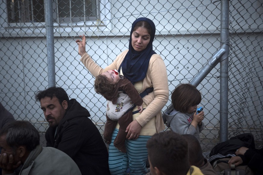 Frau mit Kind wartet auf Registierung auf Lesbos.