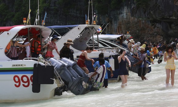 Tourists arrive in boats on the beach of Maya Bay, Phi Phi Leh island in Krabi province, Thailand, Thursday, May 31, 2018. The popular tourist destination of Maya Bay in the Andaman Sea will close to  ...