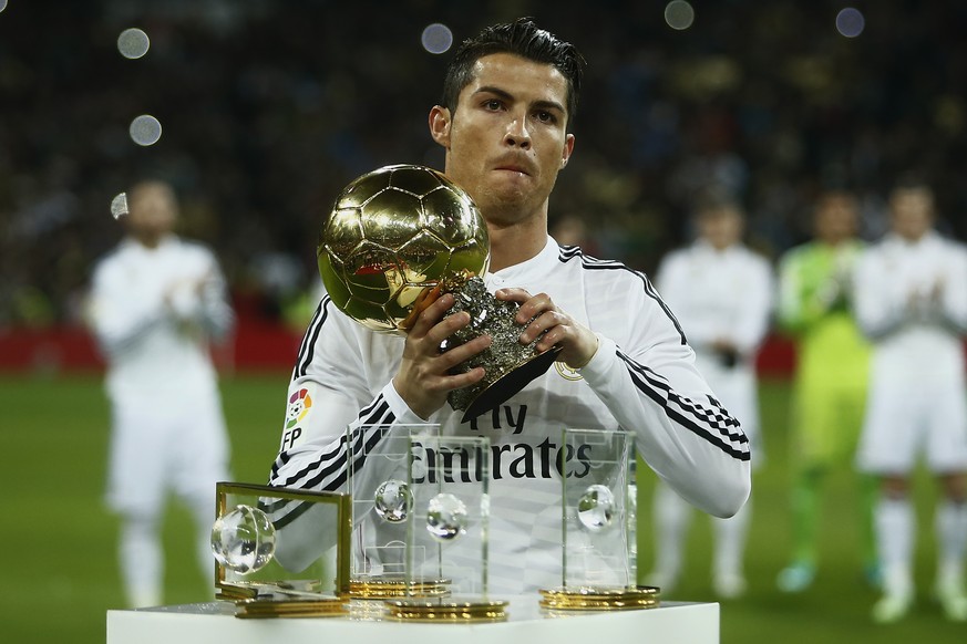 Real Madrid&#039;s Cristiano Ronaldo from Portugal holds the Balon D&#039;Or trophy before a King&#039;s Cup soccer match between Atletico de Madrid and Real Madrid at the Santiago Bernabeu stadium in ...