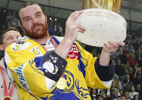 HC Davos Verteidiger Marc Gianola stemmt den Pokal in die Hoehe bei der Siegerehrung nach dem Gewinn des Meistertitels im siebten der Best of Seven Serie Eishockey Playoff-Final-Spiel der National Lea ...