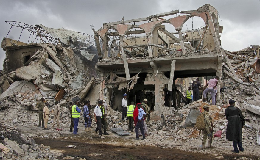 Somali security forces and others gather and search for bodies near destroyed buildings at the scene of Saturday&#039;s blast, in Mogadishu, Somalia Sunday, Oct. 15, 2017. The death toll from the huge ...