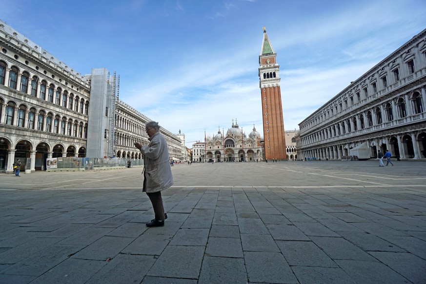 A woman walks in St. Mark&#039;s Square in Venice, Italy, Monday, March 9, 2020. Italy took a page from ChinaÄôs playbook Sunday, attempting to lock down 16 million people Äî more than a quarter of  ...