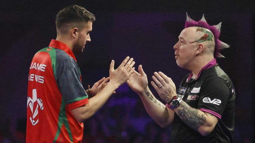 Britain&#039;s Jamie Lewis, left, is congratulated by Britain&#039;s Peter Wright following his victory day eleven of the World Darts Championship at Alexandra Palace, London, Wednesday, Dec. 27, 2017 ...