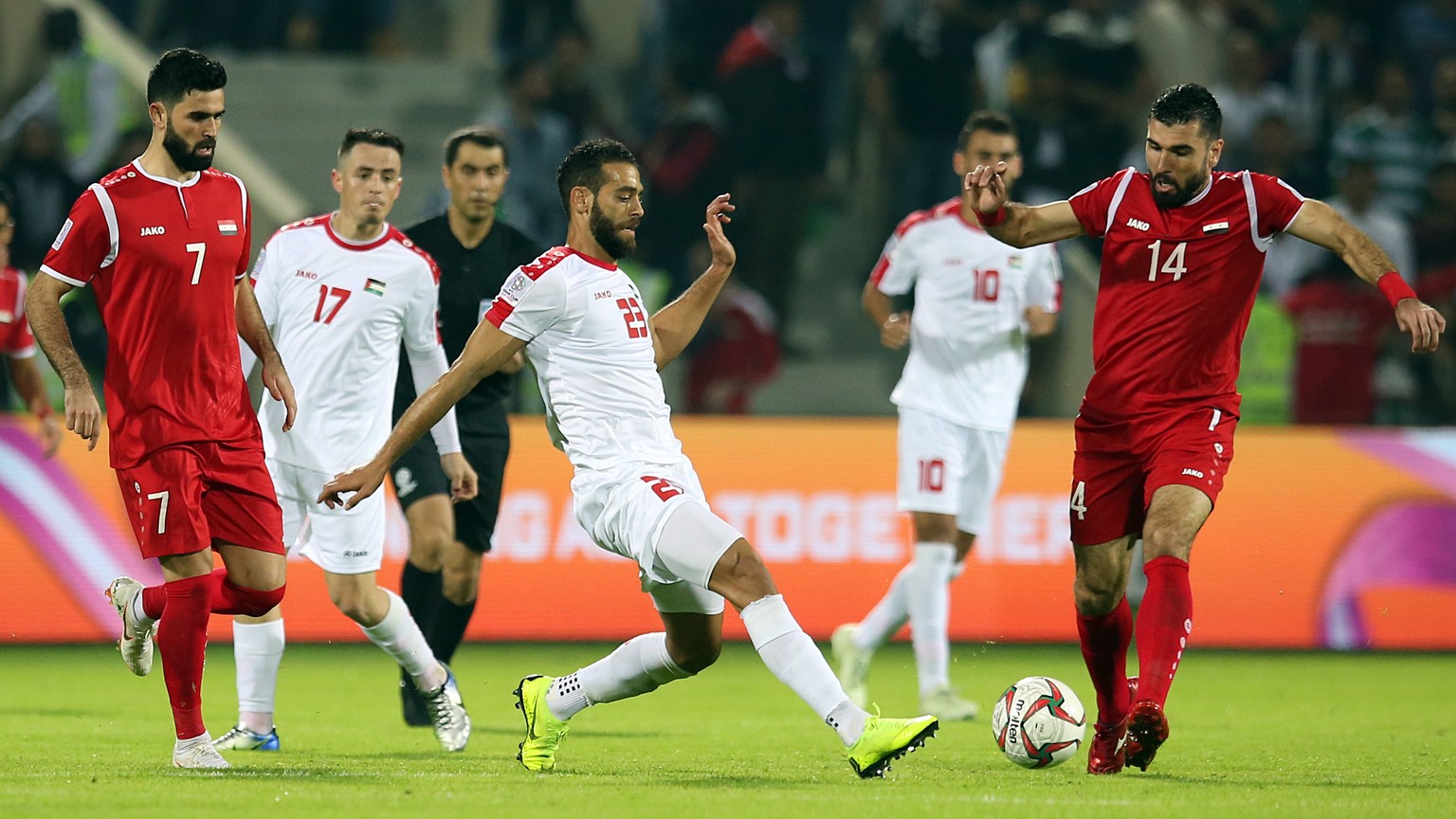 epa07265804 Tamer Hag Mohamad (R) of Syria in action against Mohammed Darwish (C) of Palestine during the 2019 AFC Asian Cup group B preliminary round match between Syria and Palestine in Sharjah, Uni ...