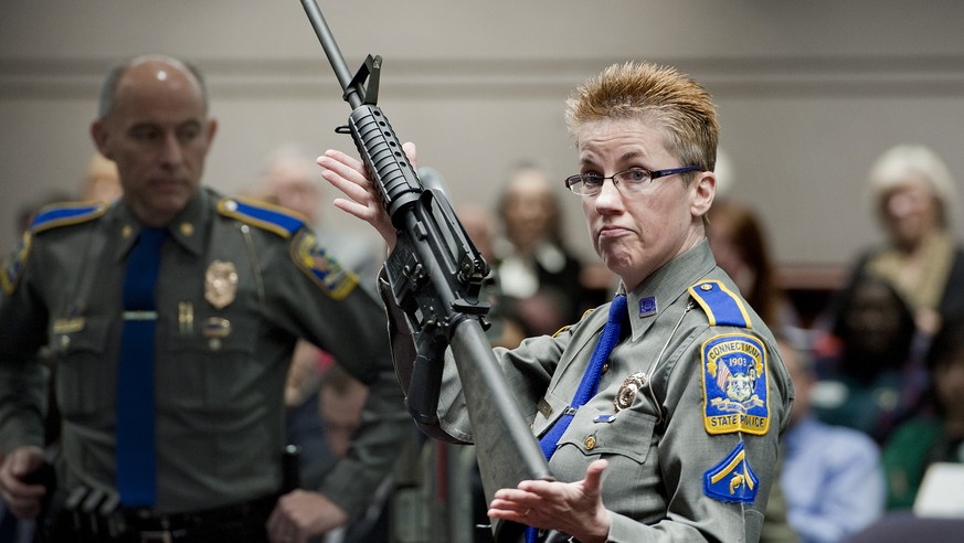FILE - In this Jan. 28, 2013, file photo, firearms training unit Detective Barbara J. Mattson, of the Connecticut State Police, holds up a Bushmaster AR-15 rifle, the same make and model of gun used b ...
