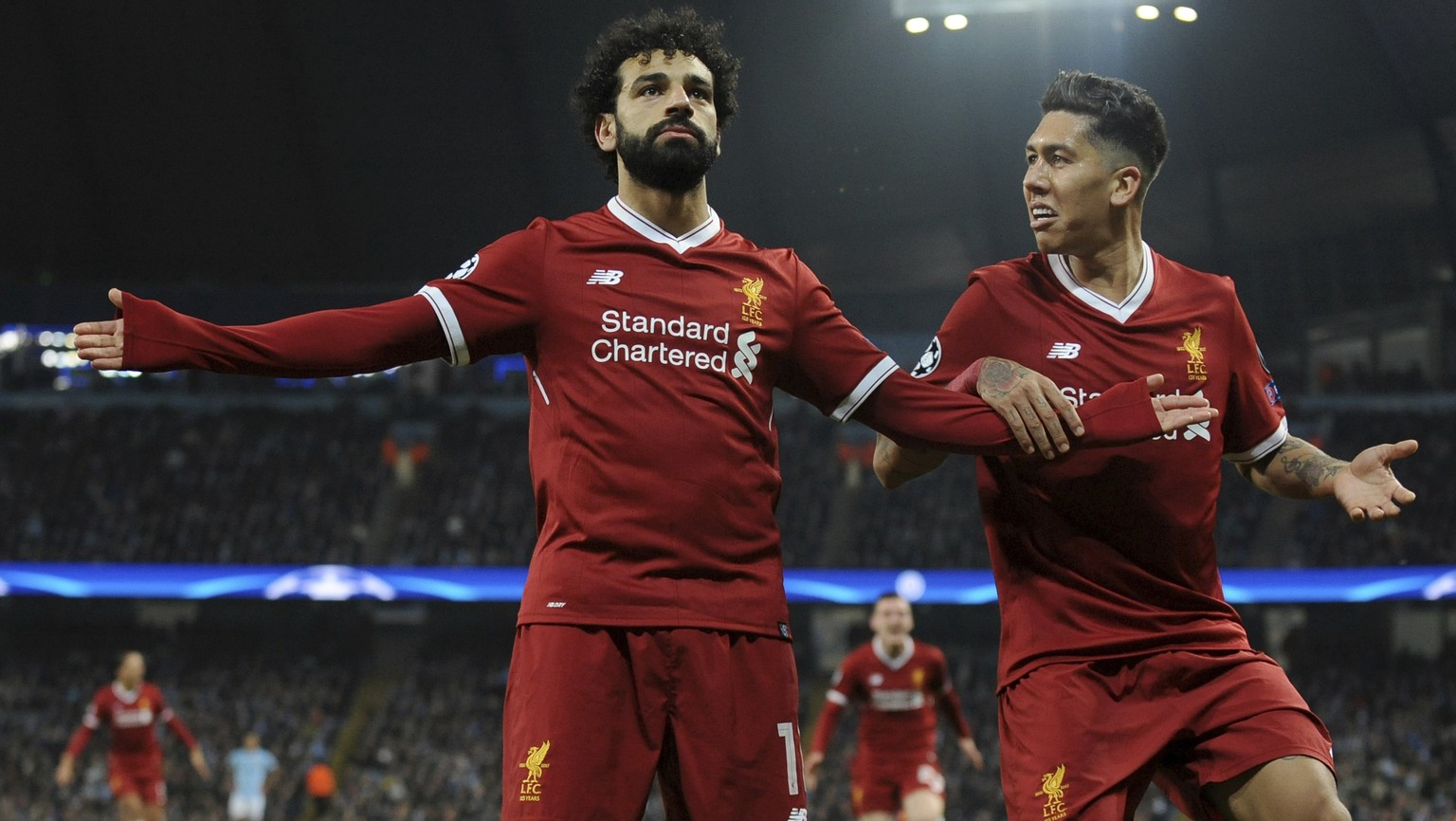 Liverpool&#039;s Mohamed Salah, left, celebrates scoring his side&#039;s first goal with Liverpool&#039;s Roberto Firmino during the Champions League quarterfinal second leg soccer match between Manch ...