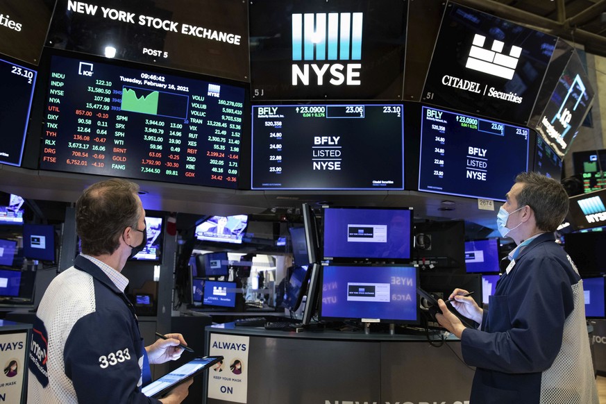 In this photo provided by the New York Stock Exchange, traders Robert Charmak, left, and Gregory Rowe, work on the trading floor, Tuesday, Feb. 16, 2021. Stocks were modestly higher in morning trading ...