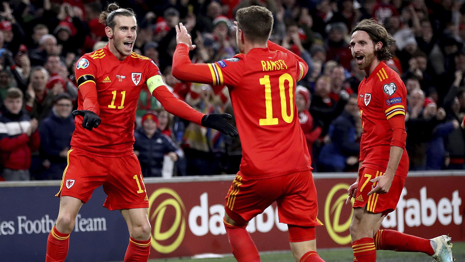 Wales&#039; Aaron Ramsey celebrates scoring his side&#039;s first goal of the game against Hungary, with team-mates Gareth Bale, left, and Joe Allen, right, during their UEFA Euro 2020 Qualifying socc ...