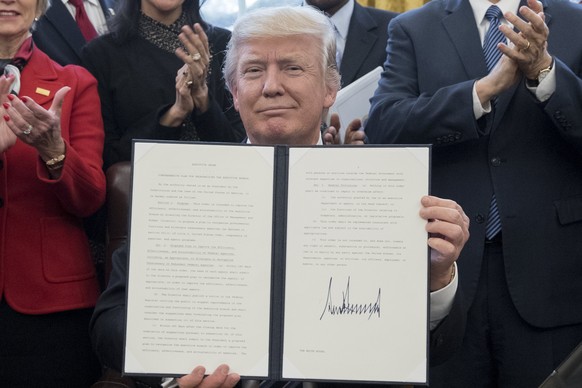 epa05846585 US President Donald J. Trump shows an executive order entitled, &#039;Comprehensive Plan for Reorganizing the Executive Branch&#039;, after signing it beside members of his Cabinet in the  ...