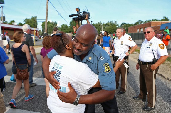 Noch 24 Stunden früher unmöglich: Eine Demonstrantin und ein Polizist umarmen sich.