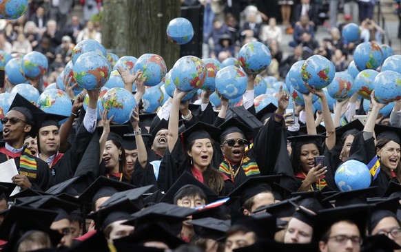 Graduates of Harvard&#039;s John F. Kennedy School of Government hold aloft inflatable globes as they celebrate graduating during Harvard University&#039;s commencement exercises, Thursday, May 30, 20 ...