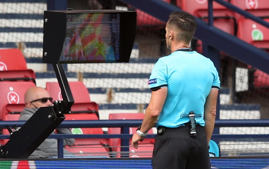 epa09283424 Spanish referee Carlos del Cerro Grande consults the VAR during the UEFA EURO 2020 group D preliminary round soccer match between Croatia and the Czech Republic in Glasgow, Britain, 18 Jun ...