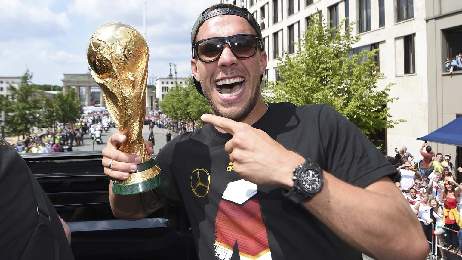 Germany&#039;s Lukas Podolski poses with the World Cup trophy during celebrations to mark the team&#039;s 2014 Brazil World Cup victory in Berlin July 15, 2014. Germany&#039;s victorious soccer team l ...