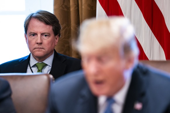 epa06957685 (FILE) - White House counsel Don McGahn (L) listens to President Donald J. Trump speak to the media before meeting with members of his administration in the Cabinet Room of the White House ...