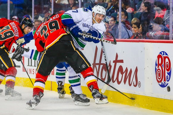 Sep 30, 2016; Calgary, Alberta, CAN; Vancouver Canucks right wing Anton Rodin (17) and Calgary Flames defenseman Deryk Engelland (29) battle for the puck during a preseason hockey game at Scotiabank S ...