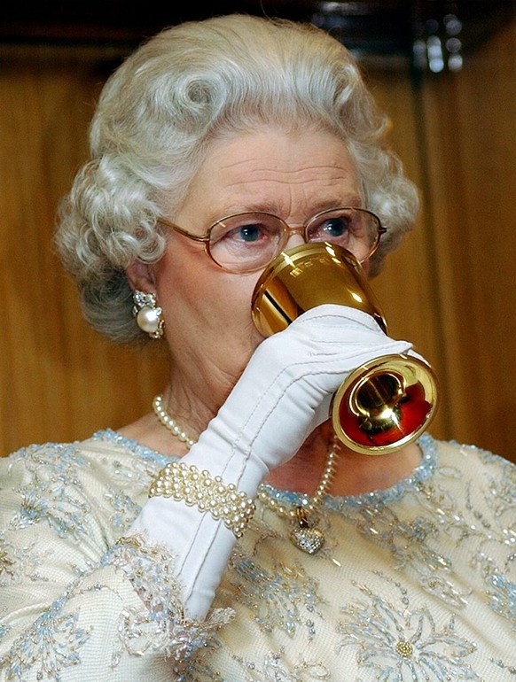 Britain&#039;s Queen Elizabeth II drinks a toast at dinner for CHOGM officials in Abuja, Nigeria, Friday 05 December 2003. EPA/KIRSTY WIGGLESWORTH/WPA POOL