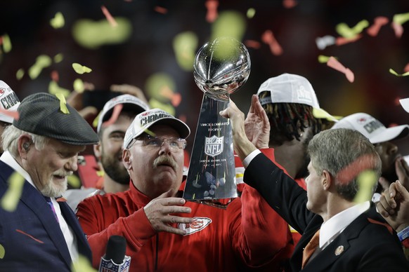 Kansas City Chiefs chairman Clark Hunt, right, hands the trophy to head coach Andy Reid after the chiefs defeated the San Francisco 49ers in the NFL Super Bowl 54 football game Sunday, Feb. 2, 2020, i ...