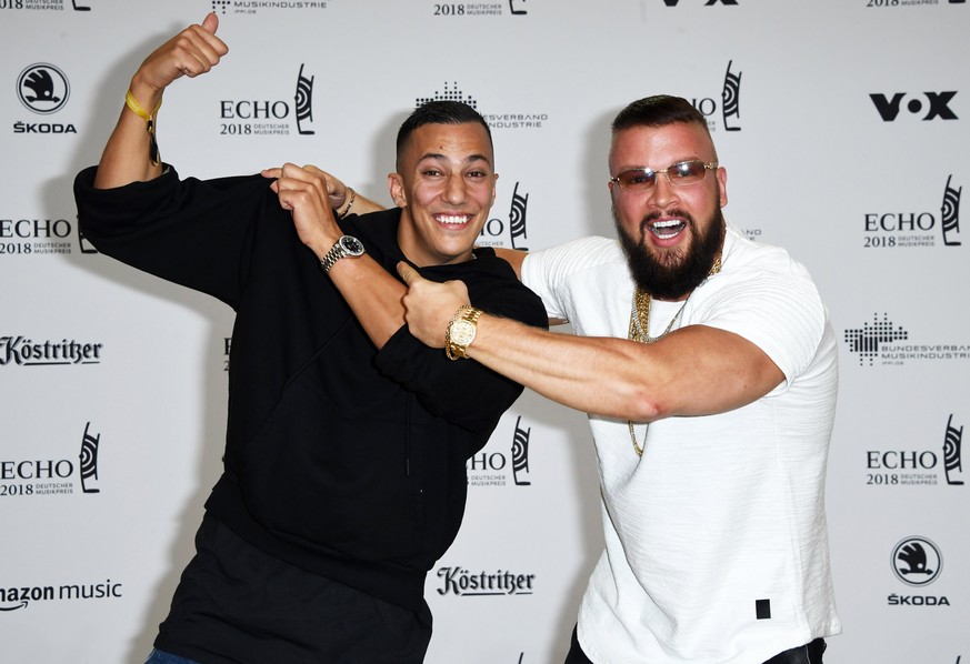 epa06664459 German musicians Kollegah (R) and Farid Bang (L) pose on the red carpet as they attend the 27th Echo 2018 music awards in Berlin, Germany, 12 April 2018. The awards are presented for outst ...