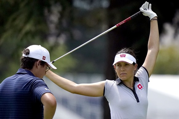 Albane Valenzuela, of Switzerland, stretches on the 11th fairway as her brother and caddy, Alexis Valenzuela, stands with her bag during a practice round prior to the women&#039;s golf event at the 20 ...