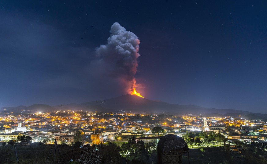 Flames and smoke billowing from a crater, as seen from the southern side of the Mt Etna volcano, tower over the city of Pedara, Sicily, Wednesday night, Feb. 24, 2021. Europe&#039;s most active volcan ...