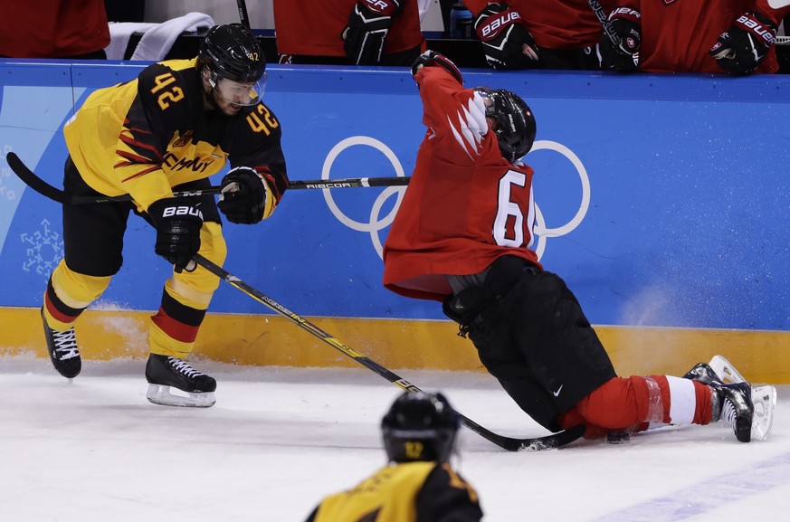 Yasin Ehliz, of Germany, left, hits Tristan Scherwey, of Switzerland, during the third period of the qualification round of the men&#039;s hockey game at the 2018 Winter Olympics in Gangneung, South K ...