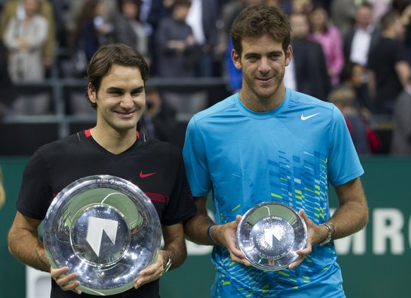 Roger Federer of Switzerland, left, and Juan Martin del Potro of Argentina hold theor trophies after the men&#039;s final at the ABN AMRO tournament at the Ahoy Arena in Rotterdam, Netherlands, Sunday ...