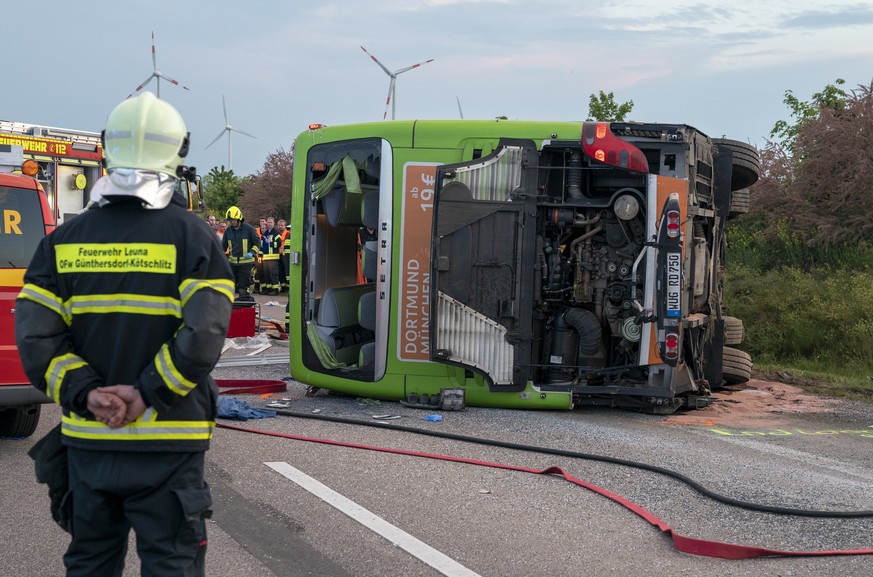 epa07585394 A fireman looks at the wreckage of a bus of Flixbus at the motorway parking place &#039;Bachfurt West&#039; near Leipzig, Germany, 19 May 2019. The bus overturned for no apparent reason. A ...
