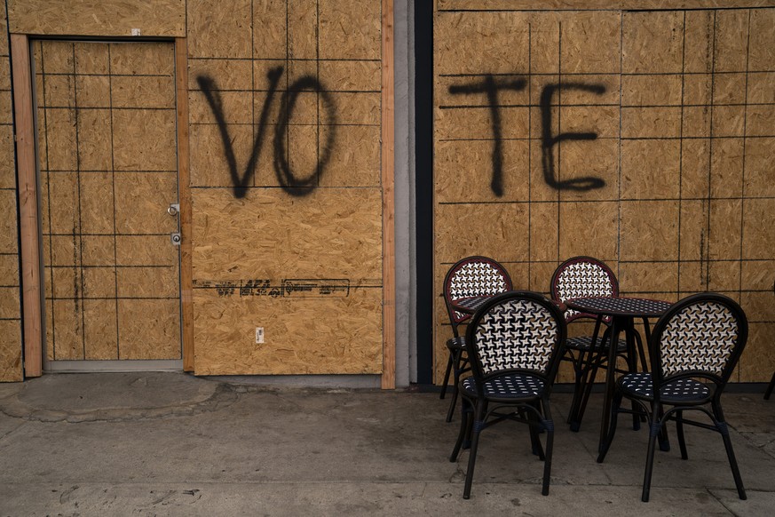 The word &quot;Vote&quot; is spray painted on plywood of a boarded-up store on Election Day Tuesday, Nov. 3, 2020, in Los Angeles. The scourge of a global pandemic produced an election season like no  ...