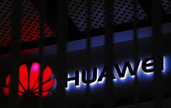 FILE - In this March 8, 2019, file photo, A logo of Huawei retail shop is seen through a handrail inside a commercial office building in Beijing. The U.S. government is imposing new restrictions on Ch ...