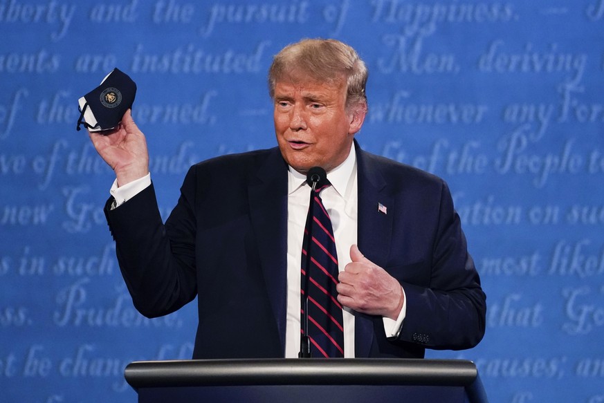 FILE - In this Sept. 29, 2020, file photo, President Donald Trump holds up his face mask during the first presidential debate at Case Western University and Cleveland Clinic, in Cleveland, Ohio. The U ...